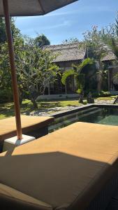 a backyard with a swimming pool and a house at Alaksa villa padang padang 6 in Bingin Beach