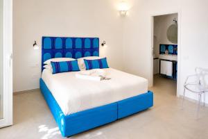 a blue and white bed in a white room at La Terrazza del Sole a Positano in Positano