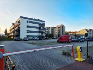 a parking lot with cars parked in front of a building at Apartament Fabryczna Premium TK in Namysłów +3 photos