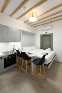 a bedroom with a bed and a table and chairs at À La Plage Residences 03 in Platis Gialos