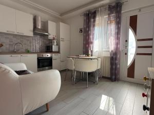a white kitchen with a table and chairs in it at New apartment Dany with parking for two in Split