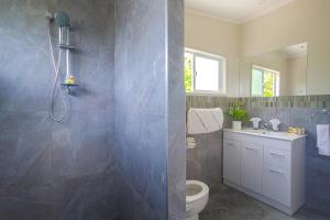 a bathroom with a shower and a toilet and a sink at Mama Taras Bungalows in Rarotonga +27 photos
