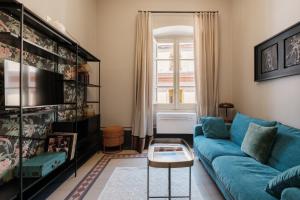 a living room with a blue couch and a window at guesthouse Electra in Iglesias