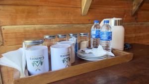 a wooden tray with drinks and bottles of water at Glenora Wood Cabin in Ella