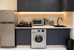 a kitchen with a washing machine and a microwave at Studio Chic avec Terrasse Verdoyante in Casablanca
