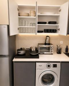 a kitchen with a washing machine and a microwave at Studio Chic avec Terrasse Verdoyante in Casablanca +7 photos