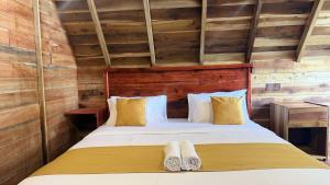 a bedroom with a bed with two towels on it at Glenora Wood Cabin in Ella