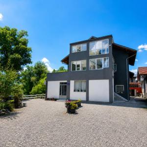 a black and white house with a gravel driveway at Apartment Bijela ladja in Bihać