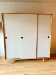 two white closet doors in a room at Freshly Renovated Black & Sand Studio in Liepāja