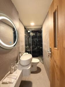 a bathroom with a sink and a toilet and a mirror at D'la Lento Hotel in Hanoi