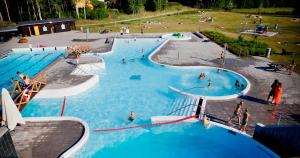 eine Gruppe von Menschen in einem großen Schwimmbecken in der Unterkunft Rosgarden in Hallstavik
