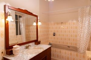 a bathroom with a sink and a tub and a mirror at Chez ma poule in Moissac +13 photos