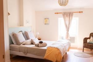 a bedroom with a bed with white pillows and a window at Chez ma poule in Moissac