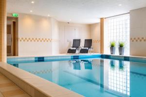a pool in a hospital room with two chairs at Paping Hotel & Spa - Rest Vonck by Flow in Ommen +14 photos