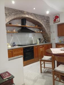 a kitchen with a stove and a stone wall at Casa Relax in Carunchio