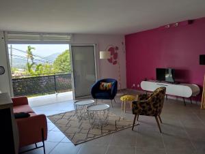 a living room with purple walls and chairs and a bed at La terrasse de Bonne terre in Saint-Claude
