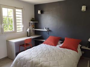 a bedroom with a bed and a desk and a window at La terrasse de Bonne terre in Saint-Claude