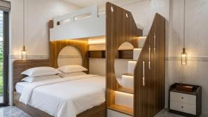 a bedroom with a bunk bed with white sheets at Mai Song Linh in Phan Rang–Tháp Chàm