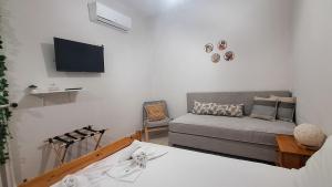 a living room with a couch and a flat screen tv at Boho Center Studio in Keramoti