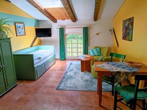 a living room with a bed and a table at Ferien am Schloss - Wohnung 2 "die Maus", Ferienwohnung am Badesee in Behren-Lübchin