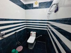a bathroom with a toilet with blue and white stripes at The Aura Grand Hotel and Cafe in Patna +25 photos