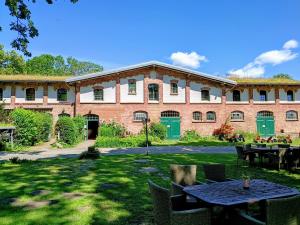 a large brick building with a table in the yard at Ferien am Schloss - Wohnung 2 "die Maus", Ferienwohnung am Badesee in Behren-Lübchin