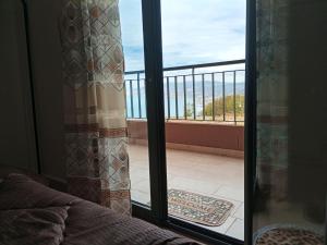 a door to a balcony with a view of the ocean at اقامة جاد in Oran