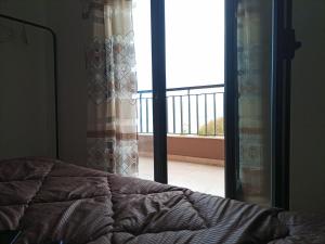 a bedroom with a bed and a view of a balcony at اقامة جاد in Oran