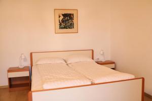 a bedroom with a bed with two nightstands and two lamps at Campanella Old Town by Mrav in Sukošan +5 photos