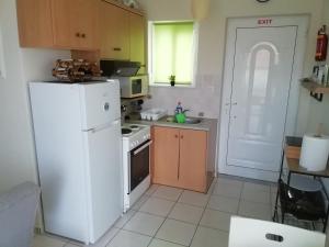 a kitchen with a white refrigerator and a sink at La petite maison in Xiropigado +3 photos