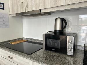 a microwave sitting on top of a kitchen counter at Casa do Adro in Viana do Castelo