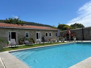 a swimming pool in front of a house at Casa do Adro in Viana do Castelo