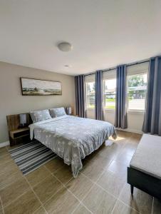 a bedroom with a bed and some windows at Mountview Maison in Red Deer