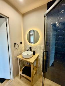 a bathroom with a sink and a shower at Freshly Renovated Black & Sand Studio in Liepāja +6 photos