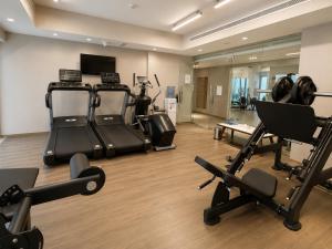 a gym with treadmills and exercise equipment in a room at Saray Deluxe Hotel Apartments in Abu Dhabi