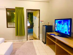 a living room with a flat screen tv on a table at Spice & Sea Resort in Kata Beach