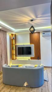 a living room with a couch and a flat screen tv at ORIGAMI APARTMENTs in Boi