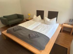 a bedroom with a large bed and a green chair at Haus Charlottenburg 2, zentrumsnah mit Blick auf die Festung, mit Sauna-Option in Königstein an der Elbe