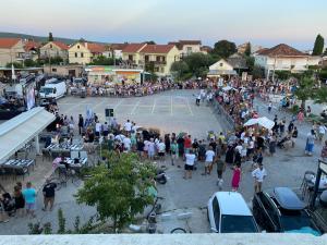 a large crowd of people standing around a tennis court at Campanella Old Town by Mrav in Sukošan