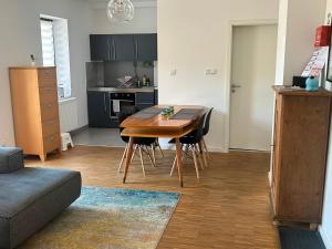 a living room with a wooden table and a kitchen at Haus Charlottenburg 2, zentrumsnah mit Blick auf die Festung, mit Sauna-Option in Königstein an der Elbe