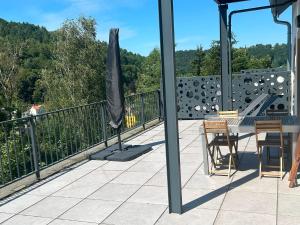 a balcony with a table and an umbrella on it at Haus Charlottenburg 2, zentrumsnah mit Blick auf die Festung, mit Sauna-Option in Königstein an der Elbe