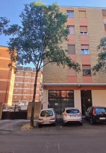 two cars parked in a parking lot in front of a building at Montegrappa smart stay Modena in Modena