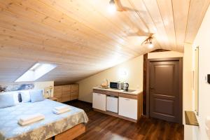 a room with a bed and a kitchen in a attic at Šv Hubertas in Karklė