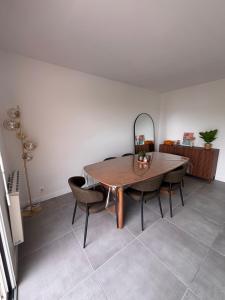 a dining room with a table and chairs and a mirror at Maison a Socoa in Urrugne