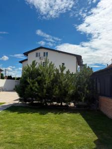 a white house with trees in a yard at SergJuli Villa in Plavecký Štvrtok