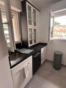 a kitchen with black and white cabinets and a sink at Maison a Socoa in Urrugne