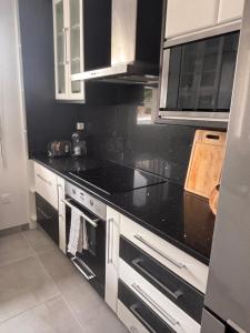 a kitchen with black counter tops and white cabinets at Maison a Socoa in Urrugne