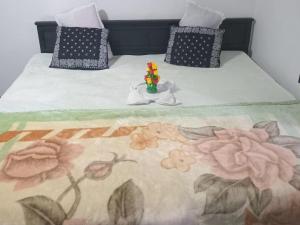 a bed with a blanket with a vase of flowers on it at Ella Cool Air Cabana in Ella