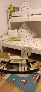 a white bunk bed with a rug on the floor at Gute Stube - Ferienhaus NaheZeit Bostalsee in Nohfelden