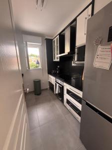 a kitchen with black and white appliances and a window at Maison a Socoa in Urrugne